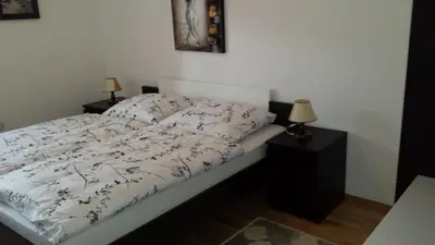 a bed with a white comforter and pillows on it at Rooms Mira G in Postojna