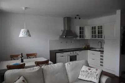a living room with a couch and a kitchen at Apartment MT Čezsoča in Bovec