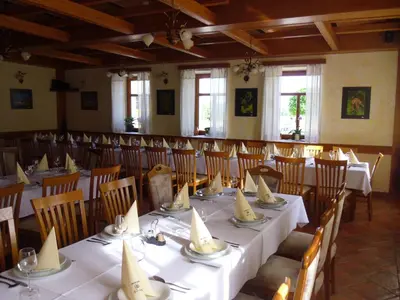 a dining room with tables and chairs with white tablecloths at Gostilna in prenočišče KOCJAN in Bizeljsko