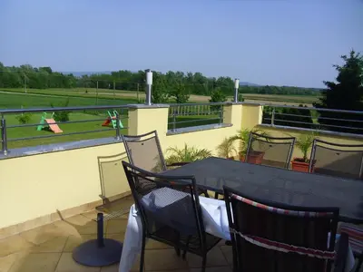 a patio with a table and chairs on a balcony at Gostilna in prenočišče KOCJAN in Bizeljsko
