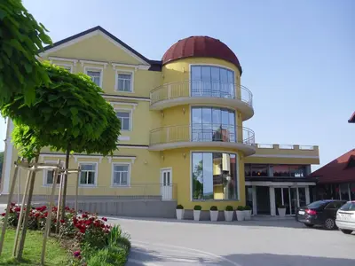 a yellow building with a dome on top of it at Gostilna in prenočišče KOCJAN in Bizeljsko