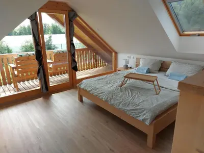 a bedroom with a bed and a balcony at Apartma Markelj in Radovljica