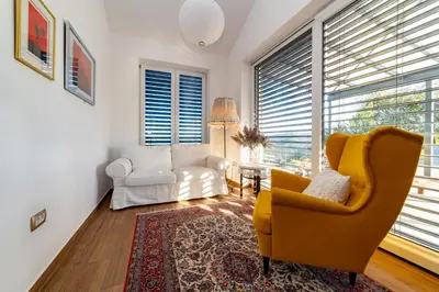 a living room with a yellow chair and a couch at Sunny Hill in Vremski Britof