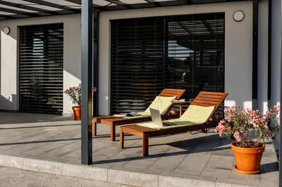 two lounge chairs and a laptop on a patio at Sunny Hill in Vremski Britof