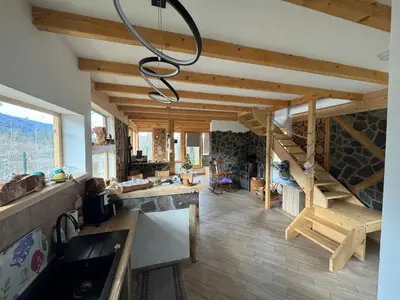 a kitchen with wooden ceilings and a chandelier at ABC Apartma Kočevsko in Kočevje