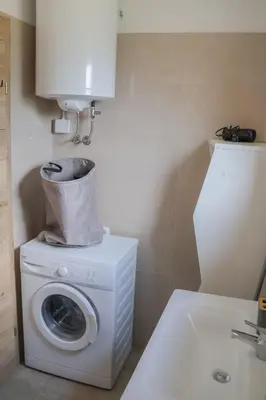 a washing machine in a bathroom next to a sink at ABC Apartma Kočevsko in Kočevje