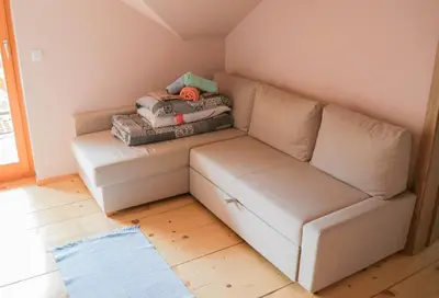 a couch with a pile of blankets and pillows at ABC Apartma Kočevsko in Kočevje