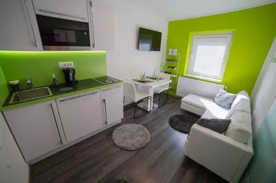 a living room with a couch and a kitchen at Naša hiša in Bohinj
