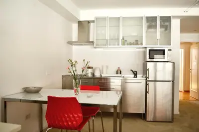 a kitchen with a table and red chairs and a refrigerator at Studio in Ljubljana Center in Ljubljana