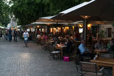 a group of people sitting at tables in an outdoor restaurant at Studio in Ljubljana Center in Ljubljana