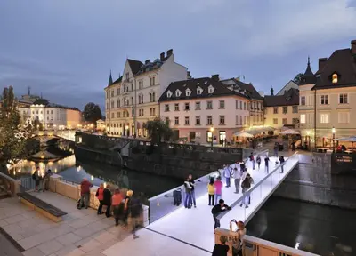 a group of people walking on a bridge over a river at Studio Emmi in Ljubljana