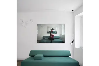 a room with a green couch and a picture on the wall at Studio Emmi in Ljubljana