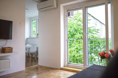 a living room with a large window and a table at Bright Apartment in Ljubljana