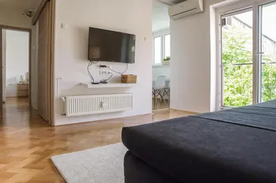 a bedroom with a flat screen tv on a wall at Bright Apartment in Ljubljana