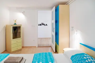 a bedroom with a bed and a dresser and a television at Apartments Your Colourful Ljubljana Home in Ljubljana