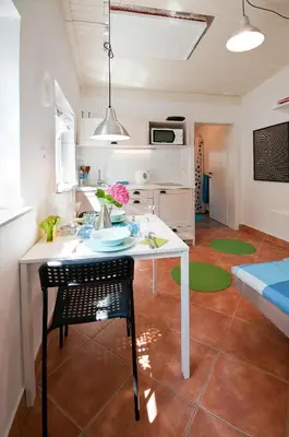 a kitchen and living room with a white table and chairs at Apartments Your Colourful Ljubljana Home in Ljubljana