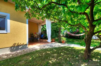 a backyard with a tree and a house at Apartments Your Colourful Ljubljana Home in Ljubljana