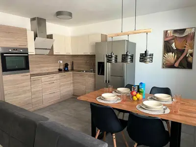 a kitchen with a wooden table and chairs in a kitchen at Apartma Rebolj in Moravske Toplice