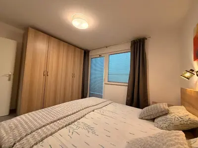 a bedroom with a large bed and a window at Apartma Rebolj in Moravske Toplice