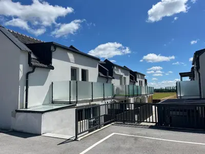 a row of apartment buildings with a parking lot at Apartma Rebolj in Moravske Toplice