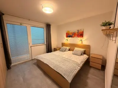 a bedroom with a bed and a large window at Apartma Rebolj in Moravske Toplice