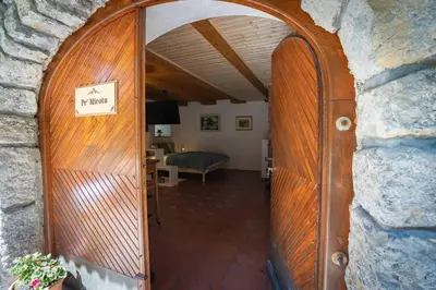 a wooden door leading into a room with a bedroom at Studio Apartment Pr' Mirotu in Osilnica