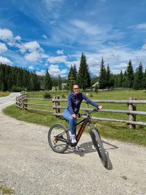 a man sitting on a bike on a road at BRINA Pokljuka in Zgornje Gorje