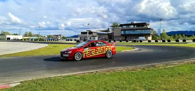 a red car is driving on a race track at Adrenalina in Krško