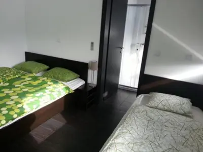 a bedroom with two beds and a mirror at Adrenalina in Krško