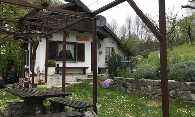 a picnic table in front of a house at Vilijev Raj, a property with cottage in the countryside in Avče