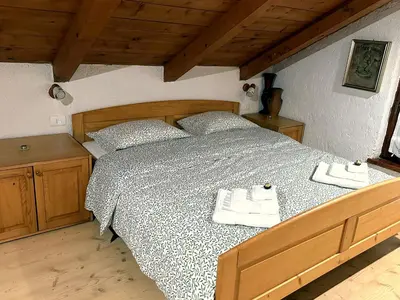 a bedroom with a bed with two towels on it at Vilijev Raj, a property with cottage in the countryside in Avče