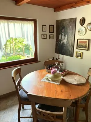 a wooden dining room table with chairs and a window at Vilijev Raj, a property with cottage in the countryside in Avče