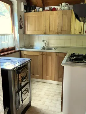 a kitchen with wooden cabinets and a stove top oven at Vilijev Raj, a property with cottage in the countryside in Avče