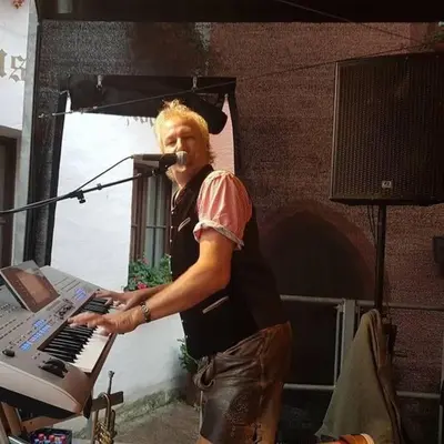a man singing into a microphone next to a keyboard at Robert's Apartment in Celje