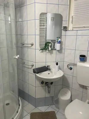 a bathroom with a sink and a toilet and a shower at Aspen Studio Apartment + FREE Parking in Ljubljana