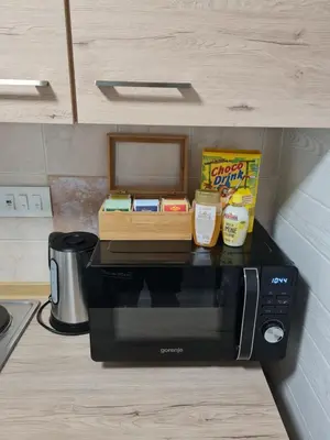a black microwave with food on top of it at Aspen Studio Apartment + FREE Parking in Ljubljana