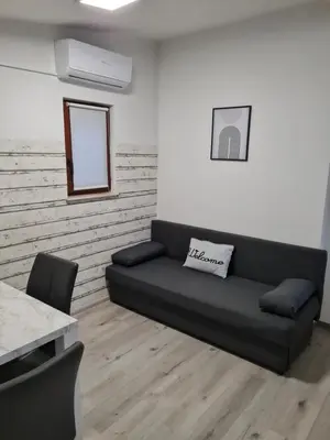 a living room with a black couch and a table at Aspen Studio Apartment + FREE Parking in Ljubljana