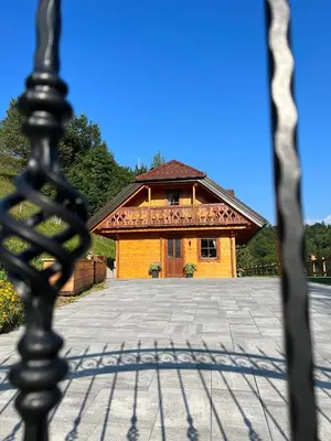 a building with a fence in front of it at Hiška Erika - Wood House Erika in Šoštanj