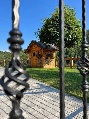 a iron fence with a house in the background at Hiška Erika - Wood House Erika in Šoštanj