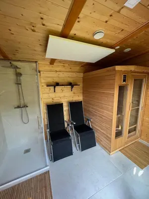 a small bathroom with two chairs and a shower at Hiška Erika - Wood House Erika in Šoštanj