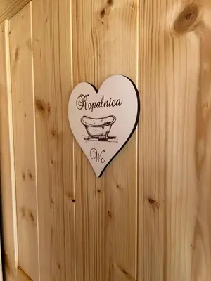 a heart shaped sign on a wooden wall at Hiška Erika - Wood House Erika in Šoštanj