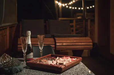 a table with a tray of food and two champagne glasses at Hiska Na Samem v Slovenj Gradcu in Slovenj Gradec