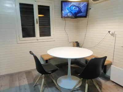 a table and chairs in a room with a tv on the wall at Počitniška hišica Patrik Terme Čatež in Mostec