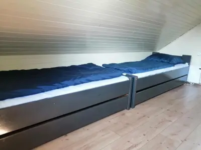 a bed with blue sheets on it in a room at Počitniška hišica Patrik Terme Čatež in Mostec