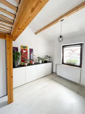 a room with white walls and a window with potted plants at Apartment *MALA* in Žalec