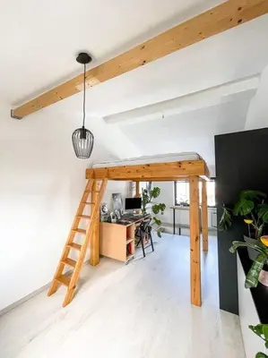 a loft bed in a room with a desk at Apartment *MALA* in Žalec