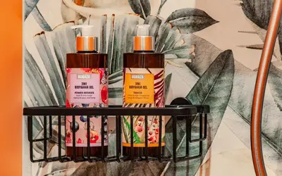 three bottles of sunscreen sitting on a shelf at SIX IN THE CITY Apartment, LJUBLJANA in Ljubljana