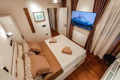 a bedroom with a bed and a flat screen tv at SIX IN THE CITY Apartment, LJUBLJANA in Ljubljana