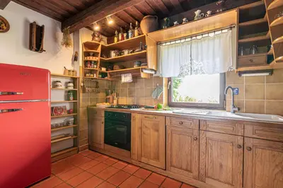 a kitchen with wooden cabinets and a red refrigerator at Holiday house Podhamer Marijan in Ljutomer
