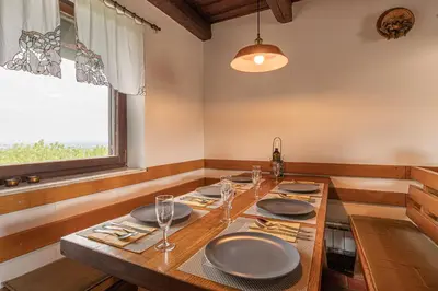 a dining room with a table with plates and glasses at Holiday house Podhamer Marijan in Ljutomer